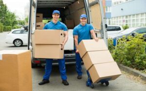 Two men carrying big size boxes to move belonging of clients
